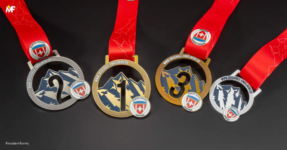 medale od szkoły narciarskiej z grafiką gór